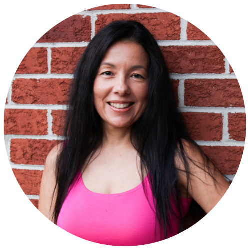 Andrea Walford, founder of Her Second Chapter, smiling in a pink top against a brick wall.